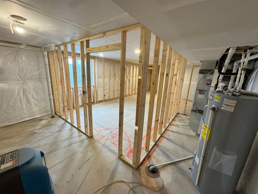 unfinished basement with wooden framing, exposed walls, and equipment visible